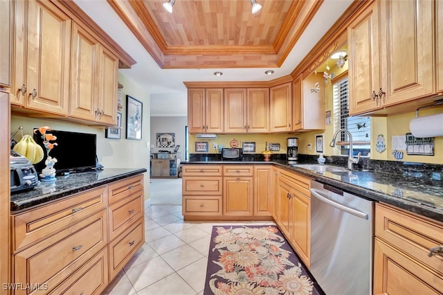 kitchen with light tile patterned floors, stainless steel dishwasher, sink, dark stone counters, and a tray ceiling