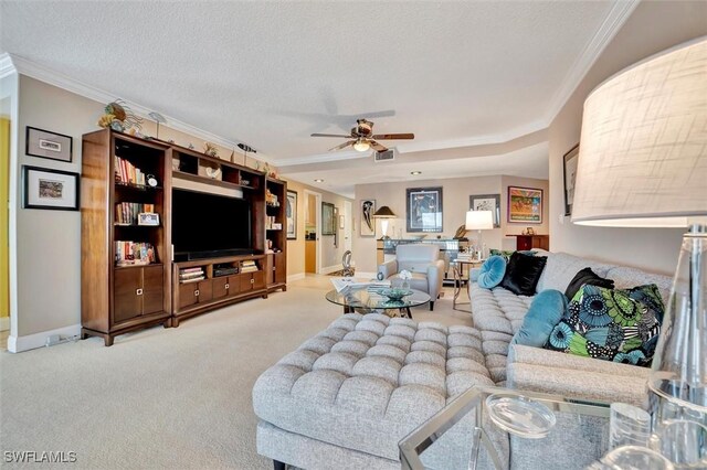 living room with carpet floors, a textured ceiling, crown molding, and ceiling fan