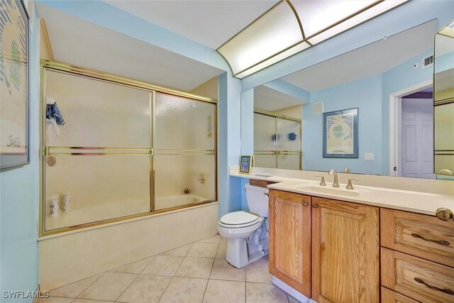 full bathroom featuring tile patterned floors, enclosed tub / shower combo, vanity, and toilet