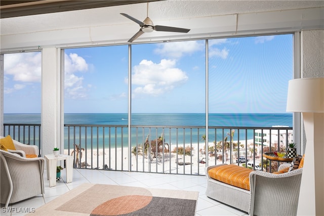 sunroom / solarium with a healthy amount of sunlight, a water view, and a beach view