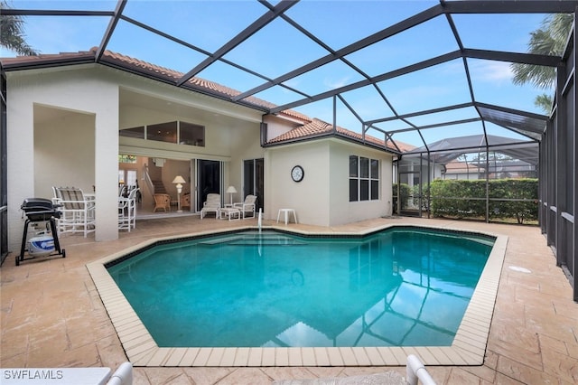 view of swimming pool with a lanai and a patio area