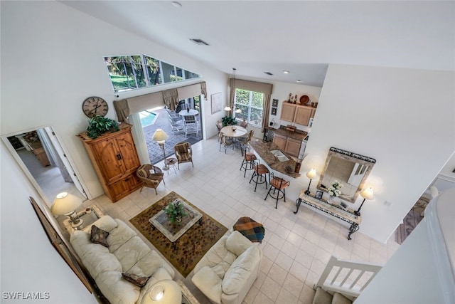 living room with light tile patterned flooring and a towering ceiling