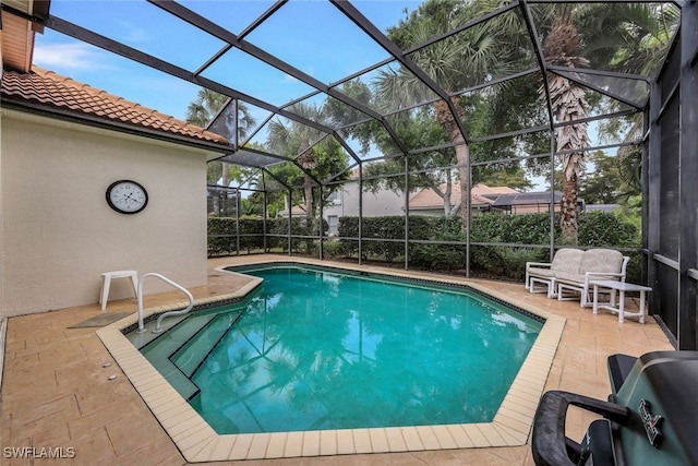 view of pool with a patio and glass enclosure