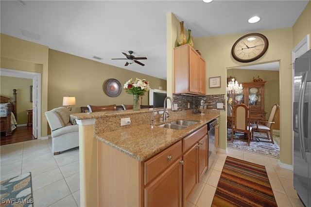 kitchen featuring tasteful backsplash, appliances with stainless steel finishes, sink, kitchen peninsula, and ceiling fan with notable chandelier