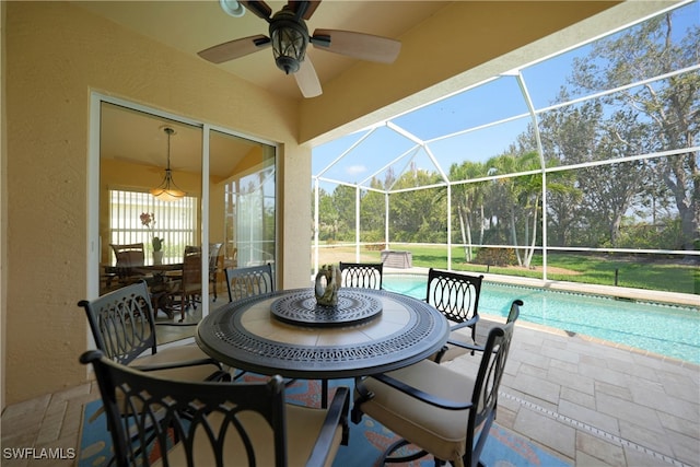 view of patio with ceiling fan and glass enclosure