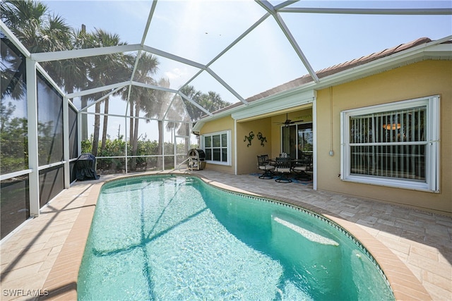 view of swimming pool with a lanai, ceiling fan, and a patio