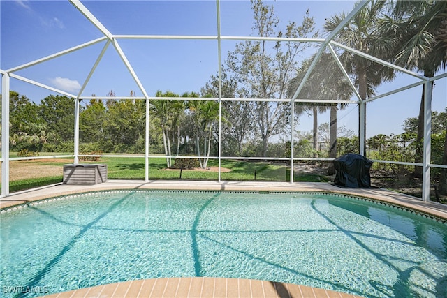 view of pool featuring a lawn and a lanai