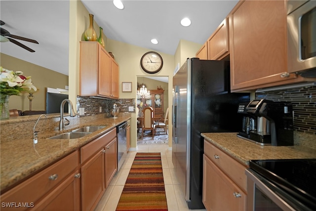 kitchen featuring tasteful backsplash, light tile patterned flooring, appliances with stainless steel finishes, sink, and lofted ceiling