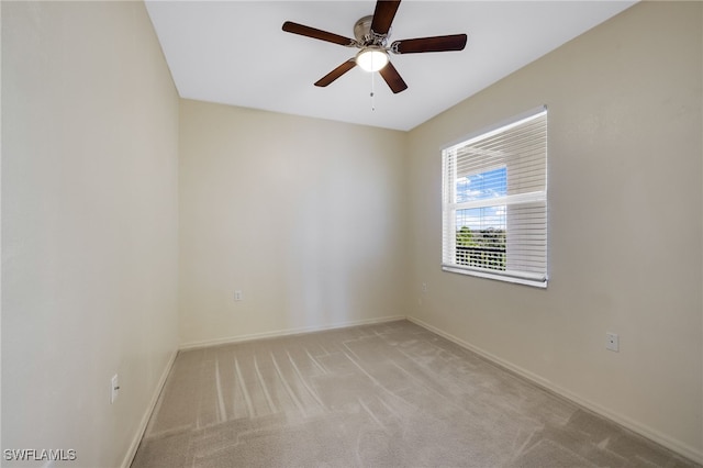 unfurnished room featuring light colored carpet, baseboards, and ceiling fan