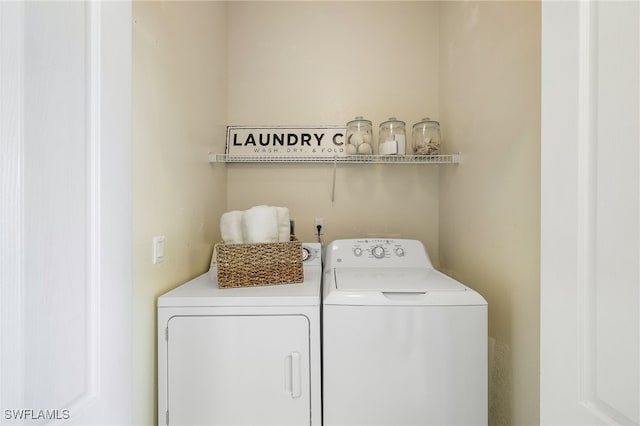 clothes washing area with independent washer and dryer and laundry area