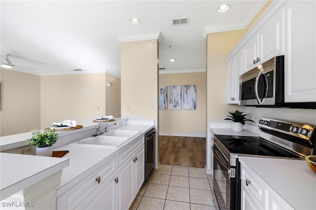 kitchen with visible vents, light tile patterned flooring, a sink, stainless steel appliances, and crown molding