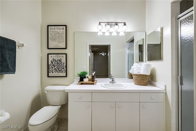 bathroom with toilet, a shower stall, and vanity