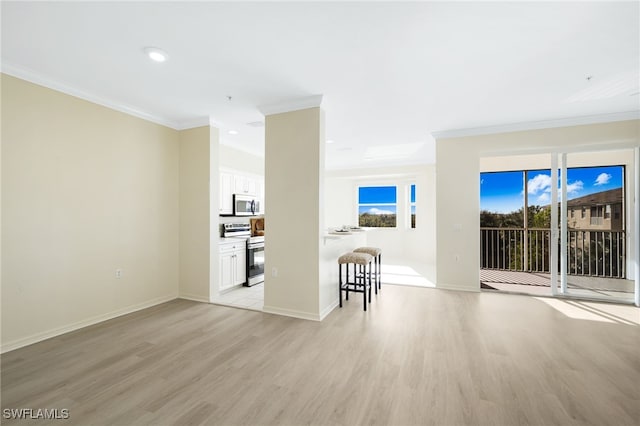 empty room featuring recessed lighting, baseboards, ornamental molding, and light wood finished floors