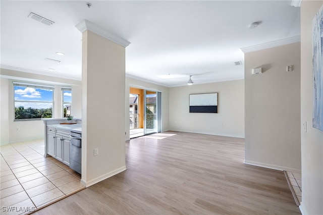 corridor featuring visible vents, baseboards, a sink, light wood-style floors, and crown molding