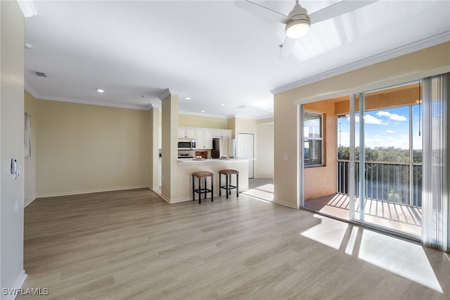 unfurnished living room with crown molding, light wood-style flooring, baseboards, and visible vents