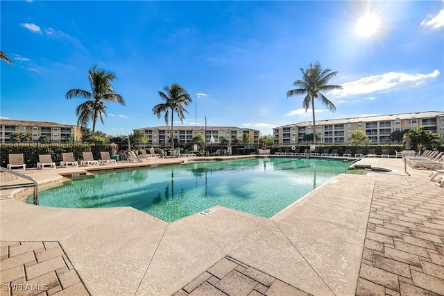 pool with a patio area and fence