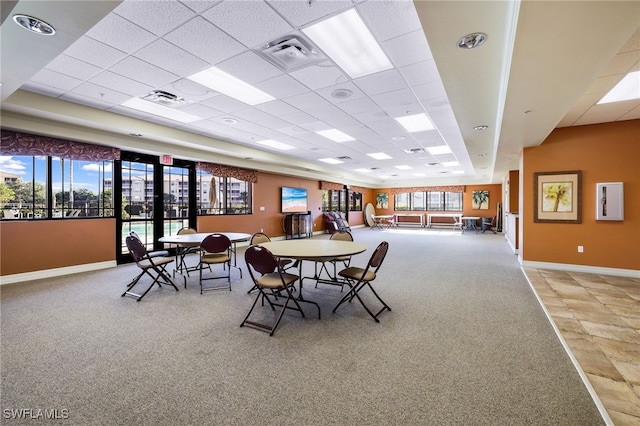 dining space with a drop ceiling, visible vents, and baseboards