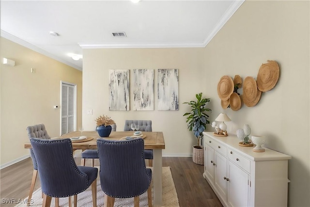 dining room featuring dark wood-type flooring, baseboards, visible vents, and ornamental molding