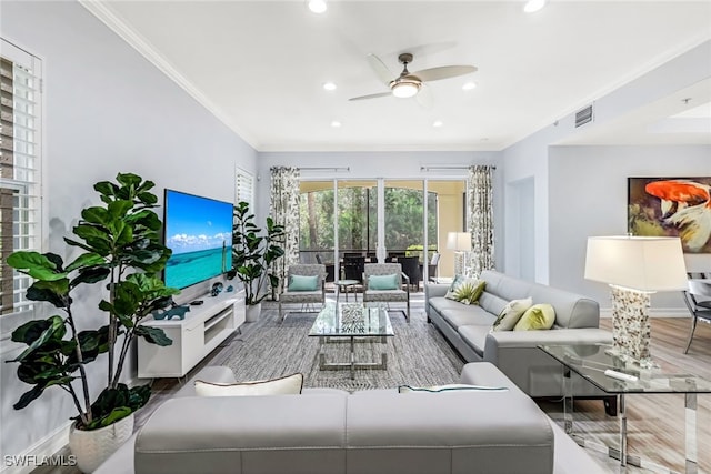 living room with hardwood / wood-style flooring, ceiling fan, and ornamental molding