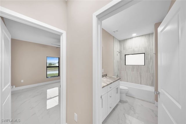 full bathroom featuring vanity, tiled shower / bath, and toilet