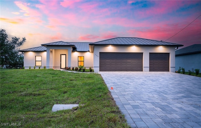 view of front of house featuring a garage and a lawn