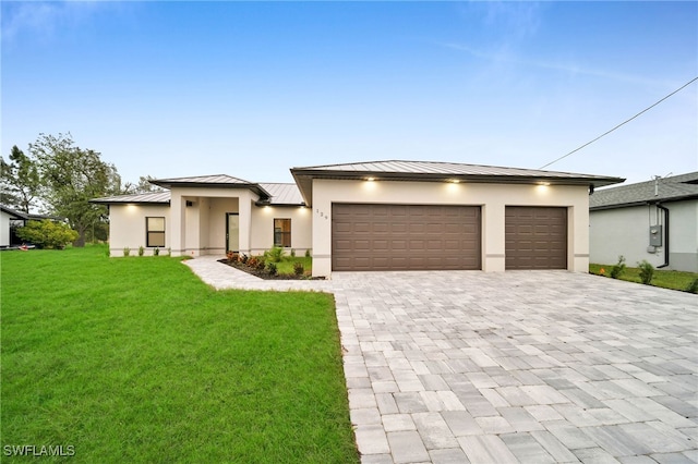 prairie-style house featuring a garage and a front yard