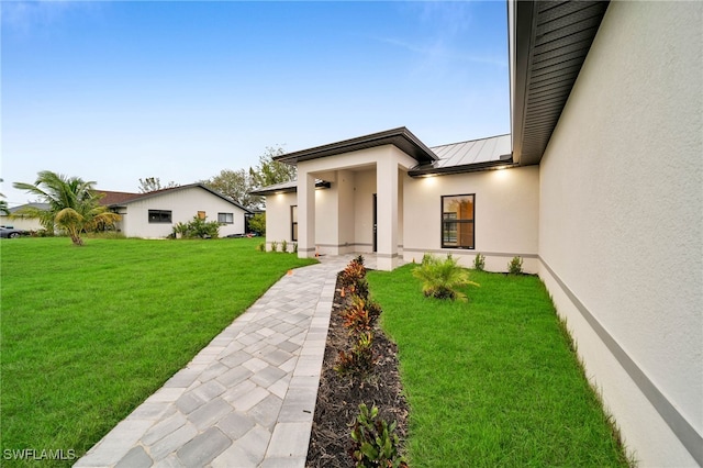 view of exterior entry featuring a yard