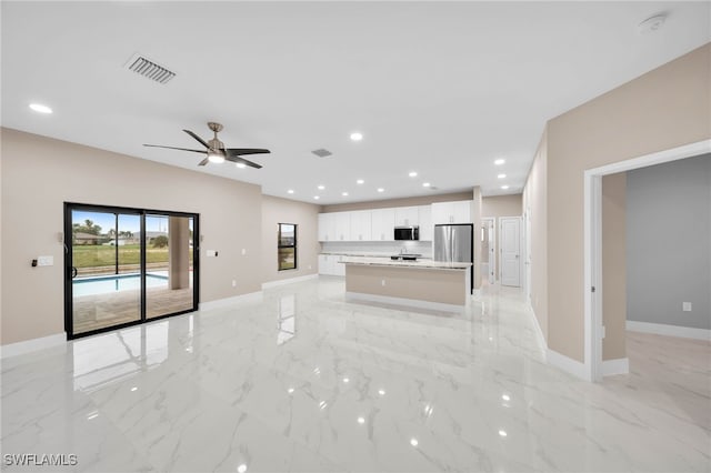 unfurnished living room featuring ceiling fan