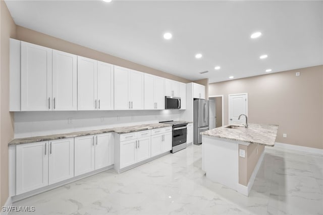 kitchen with white cabinets, a center island with sink, and appliances with stainless steel finishes