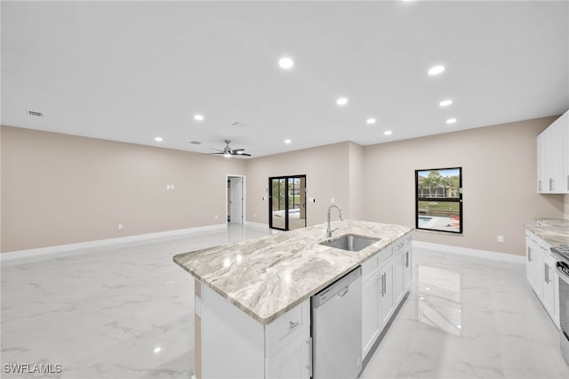 kitchen featuring a center island with sink, white cabinets, sink, light stone countertops, and appliances with stainless steel finishes