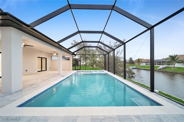 view of swimming pool with ceiling fan, a lanai, a water view, and a patio area