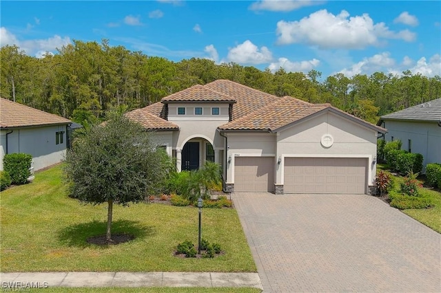 mediterranean / spanish home with a garage and a front yard