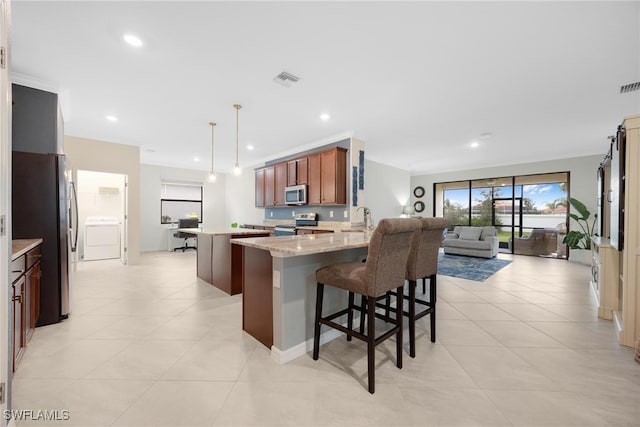 kitchen with light stone counters, appliances with stainless steel finishes, decorative light fixtures, light tile patterned floors, and sink