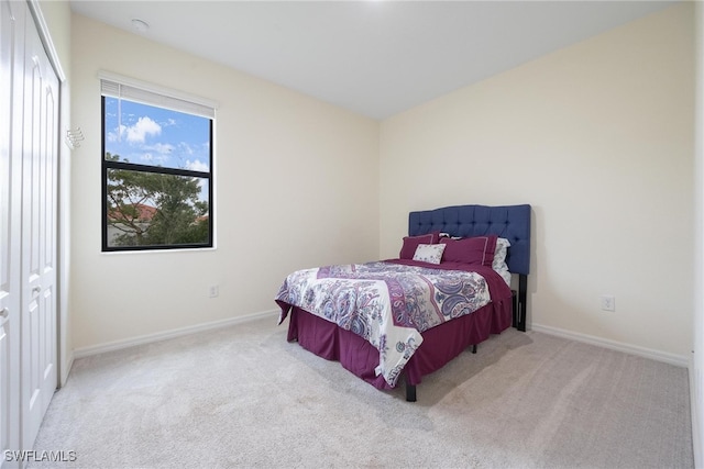 bedroom featuring light colored carpet and a closet