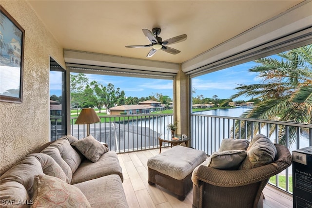 sunroom / solarium with a water view and ceiling fan