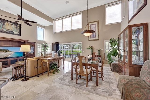 dining room featuring ceiling fan and a towering ceiling