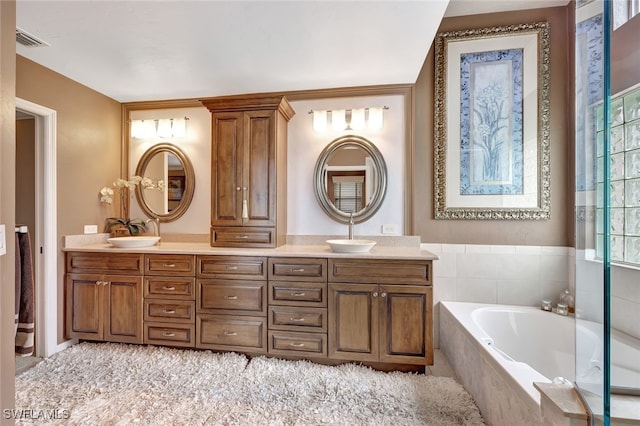 bathroom featuring vanity and a relaxing tiled tub