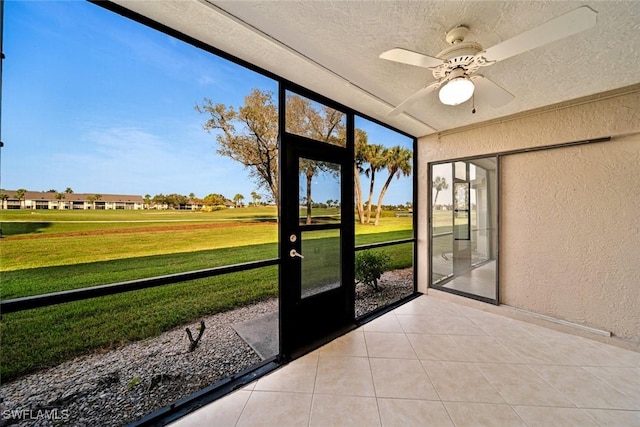 unfurnished sunroom featuring ceiling fan