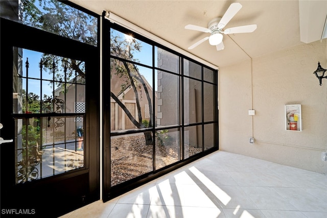 unfurnished sunroom with ceiling fan and a healthy amount of sunlight