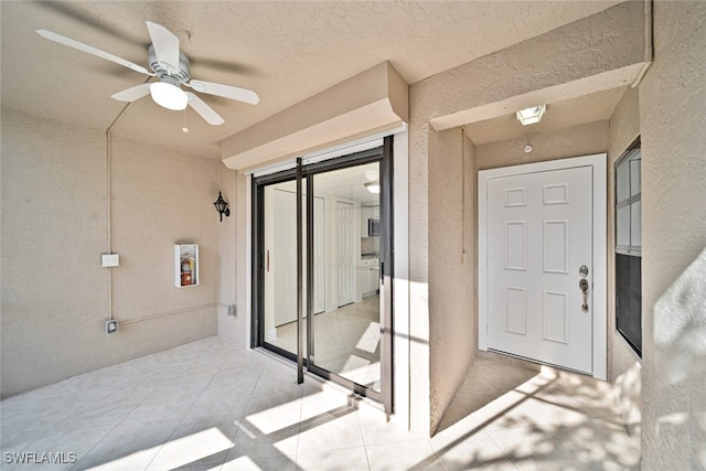 doorway to property with a patio area and ceiling fan