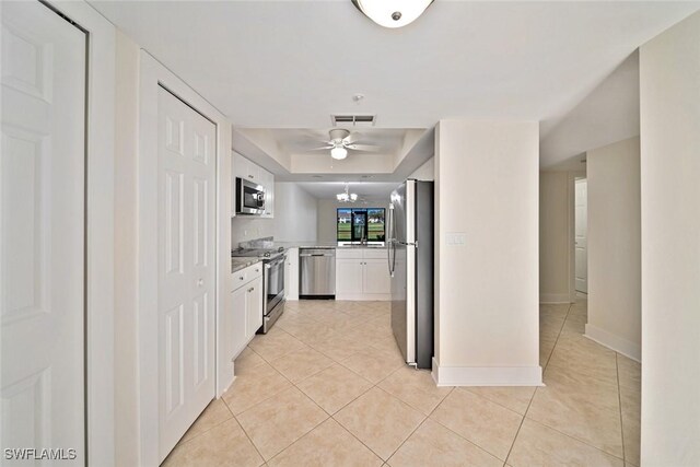 kitchen with ceiling fan, white cabinets, light tile patterned flooring, and appliances with stainless steel finishes