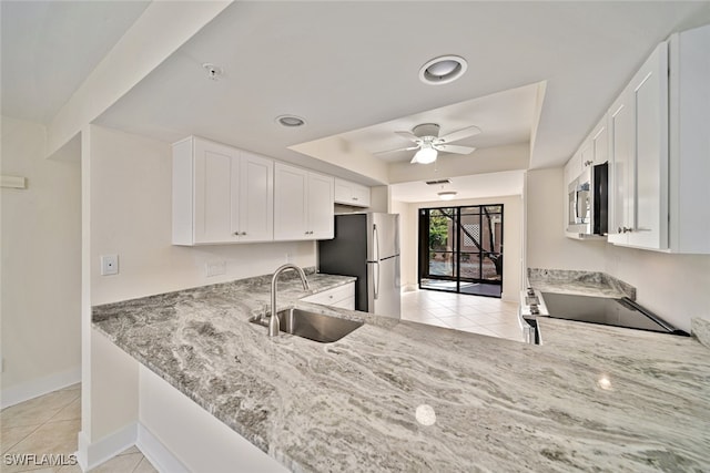 kitchen featuring white cabinetry, sink, light stone counters, and appliances with stainless steel finishes