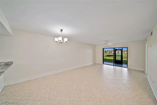 unfurnished room featuring ceiling fan with notable chandelier and light tile patterned floors