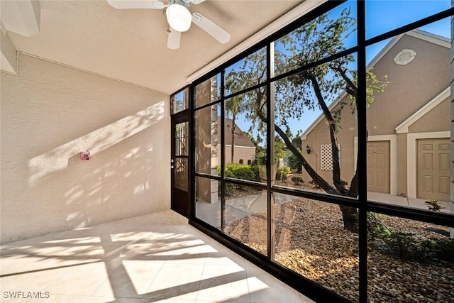 unfurnished sunroom featuring ceiling fan