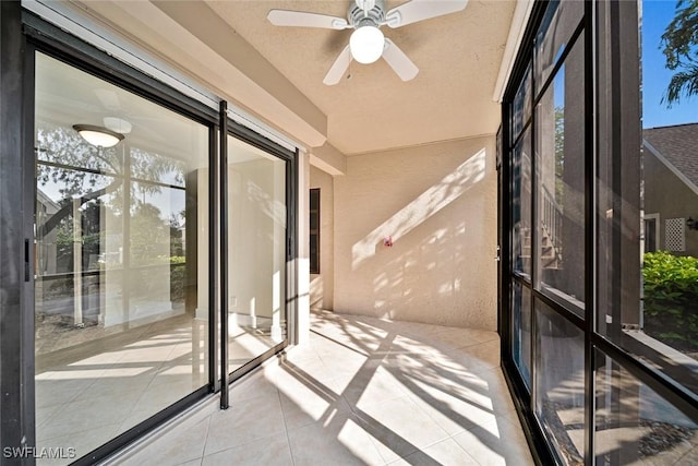 unfurnished sunroom featuring ceiling fan