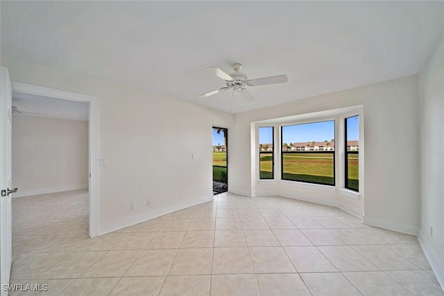 unfurnished room with light tile patterned floors and ceiling fan