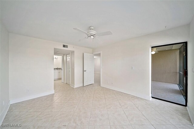 tiled empty room featuring ceiling fan