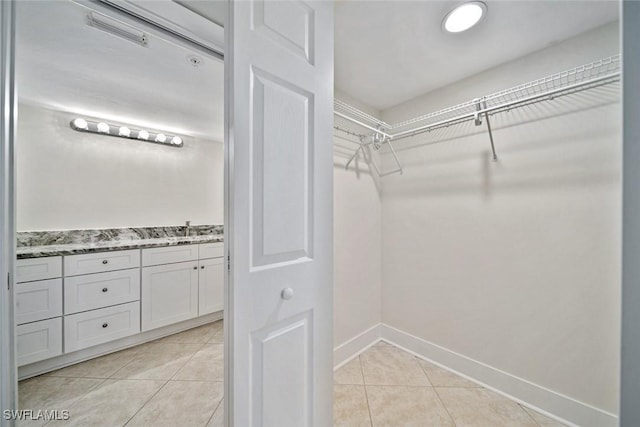 walk in closet with light tile patterned floors