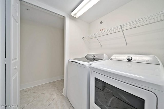 laundry area featuring washer and clothes dryer and light tile patterned floors