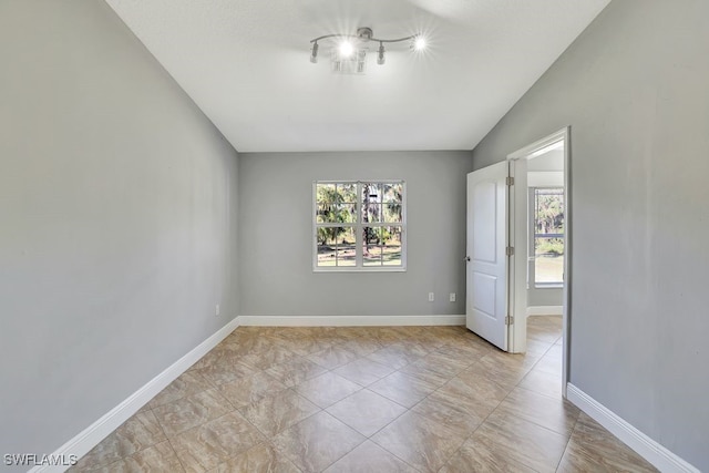 spare room featuring lofted ceiling